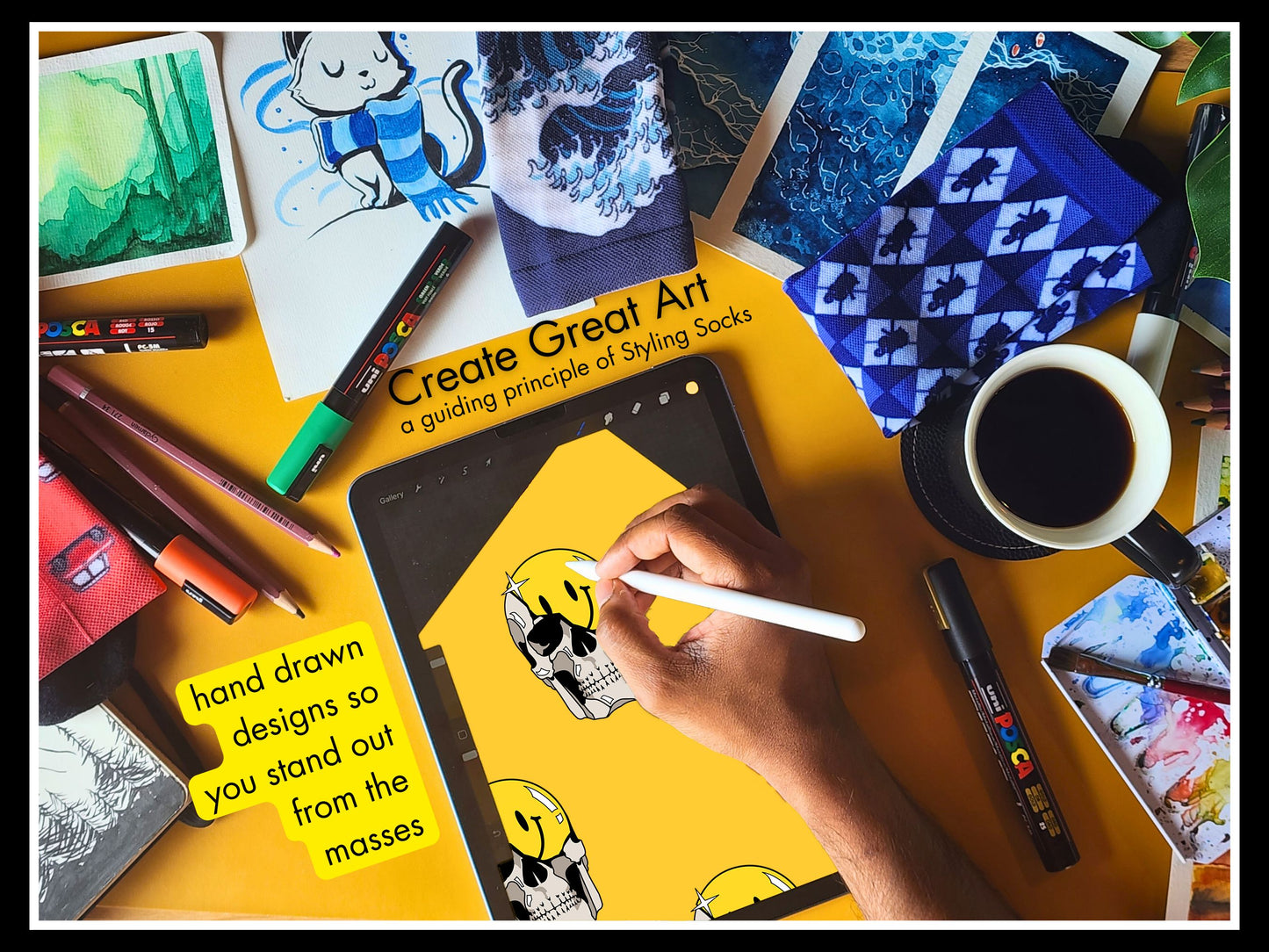 Styling Socks Artistic drawing the Grin & Grim Design on iPad with messy art table, coffee, and art supplies on a yellow surface.
