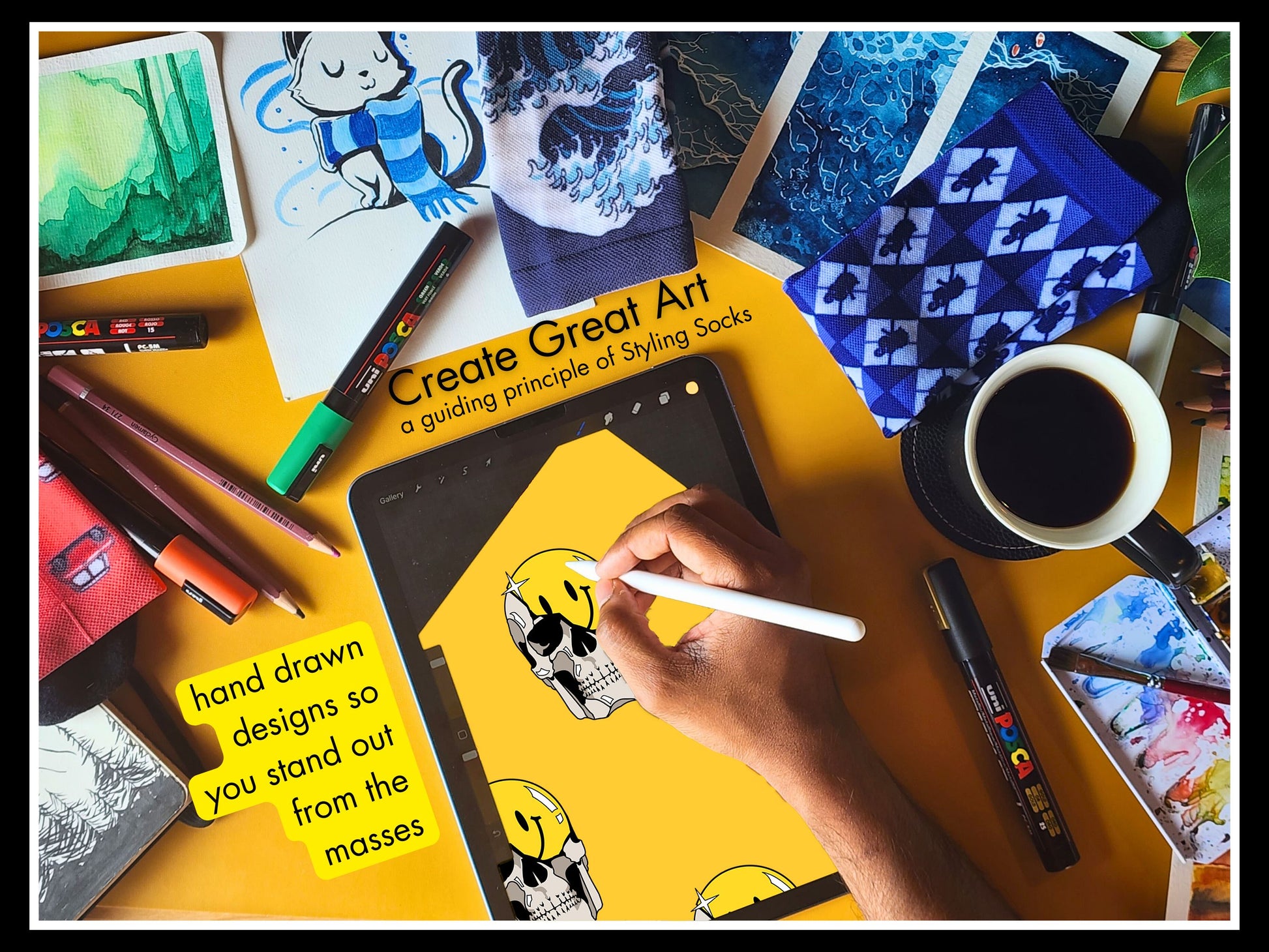 Styling Socks Artistic drawing the Grin & Grim Design on iPad with messy art table, coffee, and art supplies on a yellow surface.